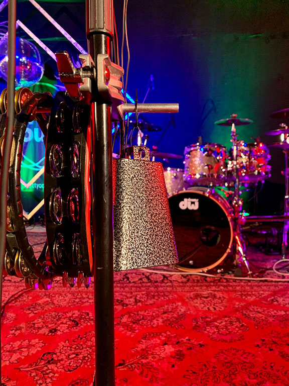 Detailaufnahme eines Schlagzeugs und Percussion-Zubehörs auf Bühne – bereit für Live-Musik