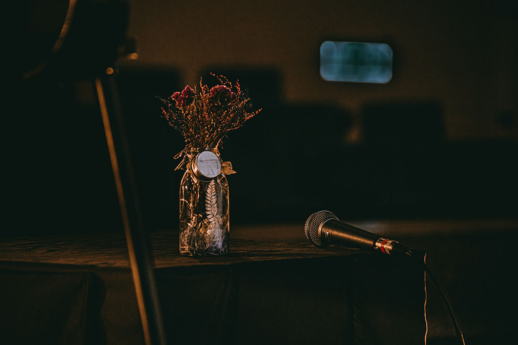 Stimmungsvolle Bühne mit Mikrofon und Trockenblumen – Atmosphäre vor- oder nachdem Auftritt
